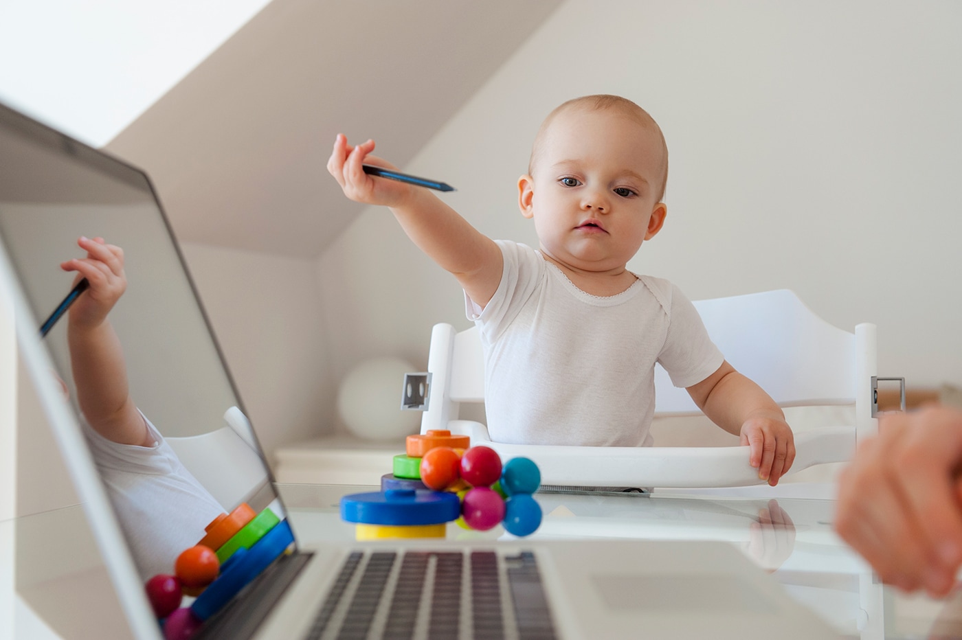 Ein Baby im Hochstuhl mit Spielzeug.